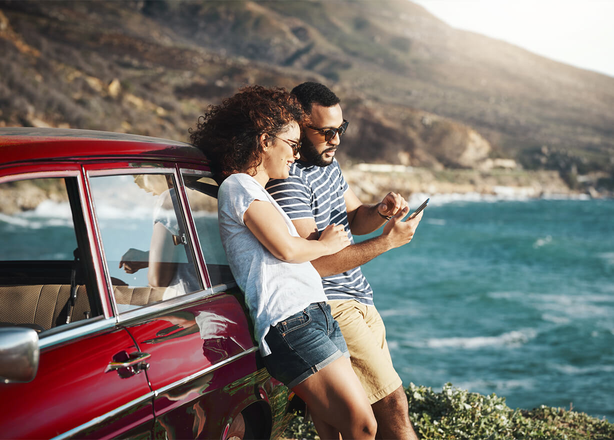 Couple using phone at the coast