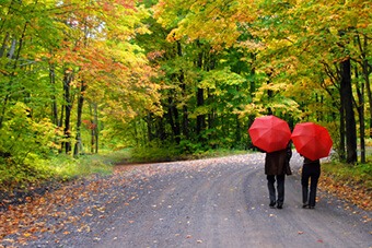 Couple walking under red umbrellas