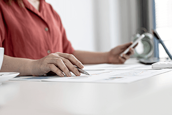 Woman writing whilst browsing on phone