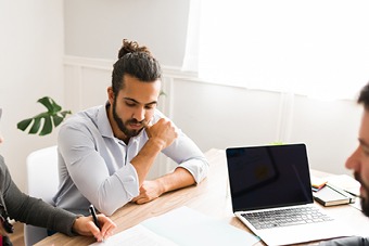 man looking at sheet of paper
