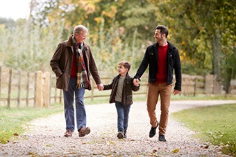 Grandfather, father and son walking through the countryside in Autumn