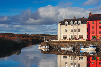 Two buildings next to lake reflecting on the water