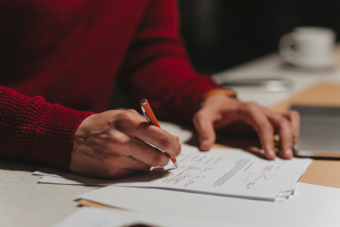 Person in a red jumper writing something 