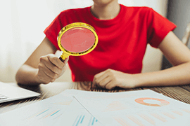 Woman looking through magnifying glass