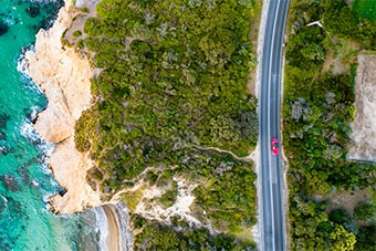 Red Car Driving on Coast