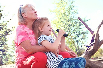 Grandma and grandchild using binoculars