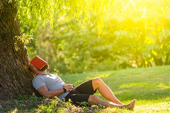 Man resting against tree