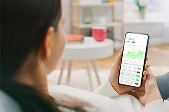 Woman using mobile to invest