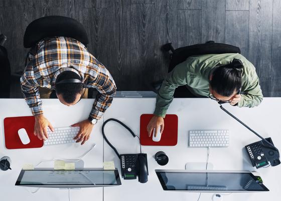 Two people sat at a desk