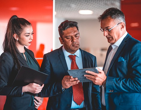 People in an office reading a tablet 
