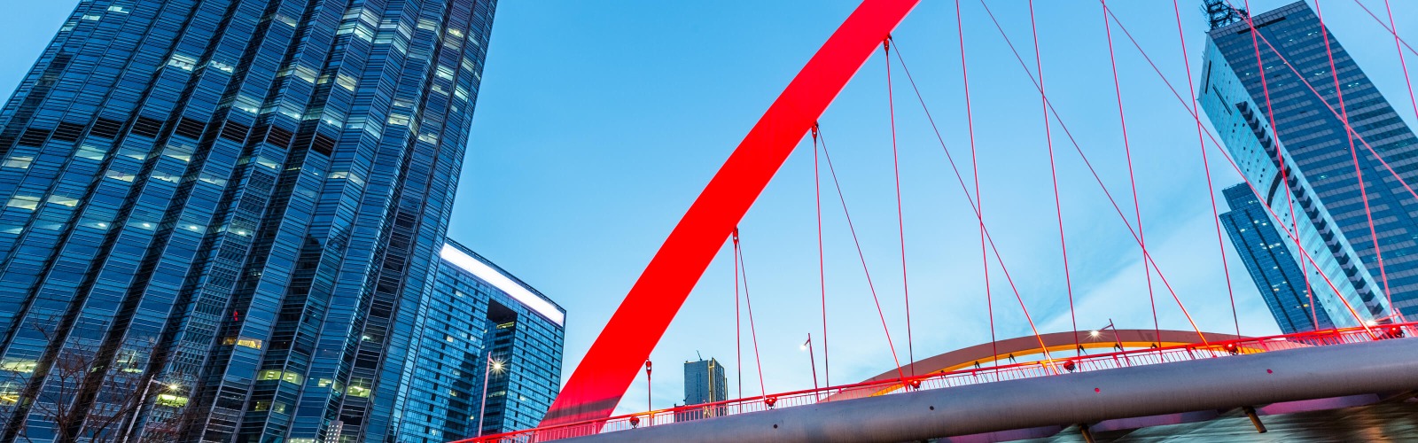 Red bridge with sky scrapers behind 