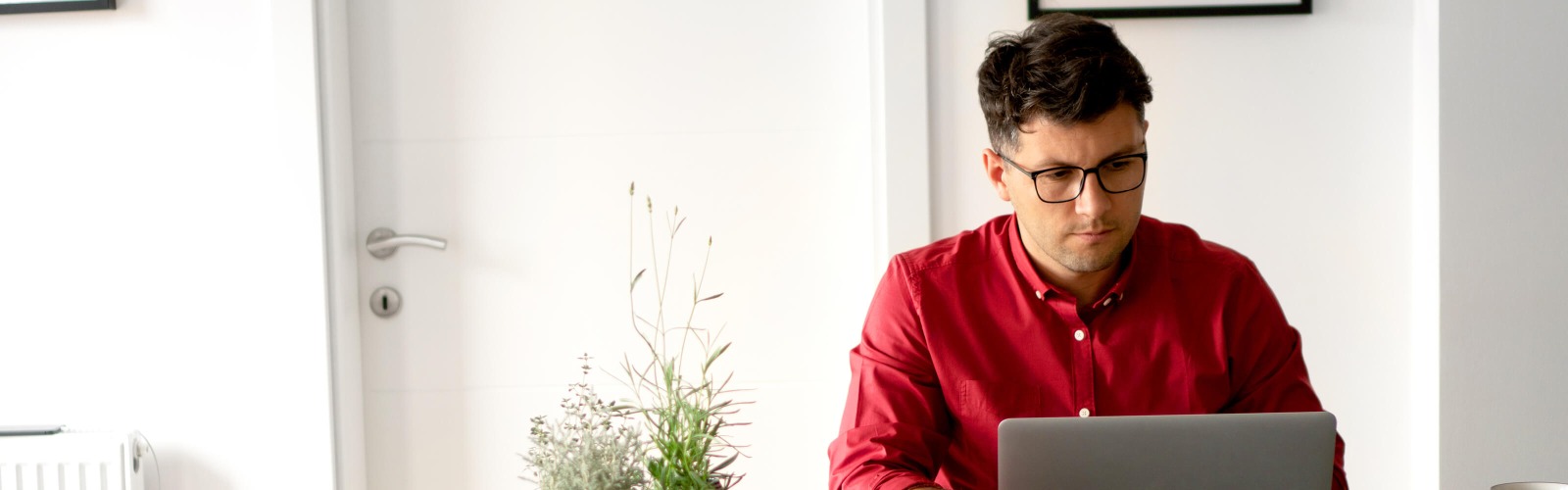 man on laptop in red shirt