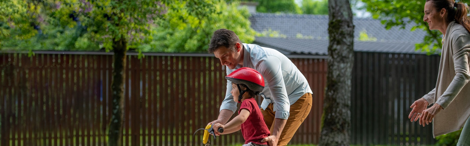 father pushing child on bike