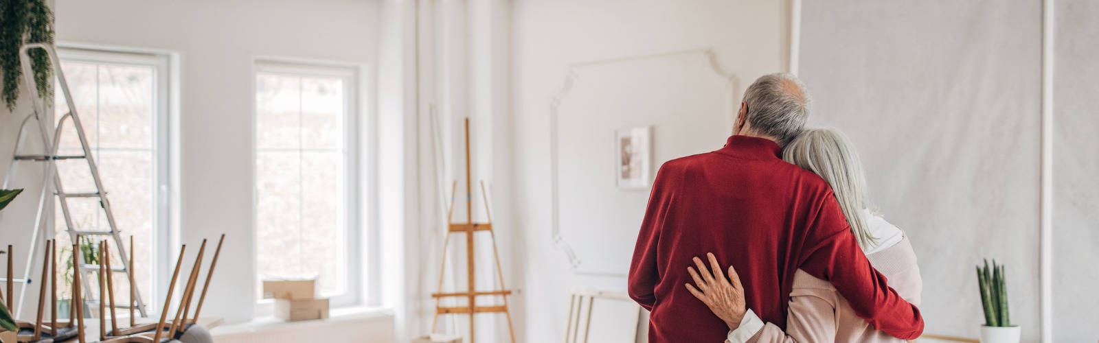 A couple hugging while decorating a room