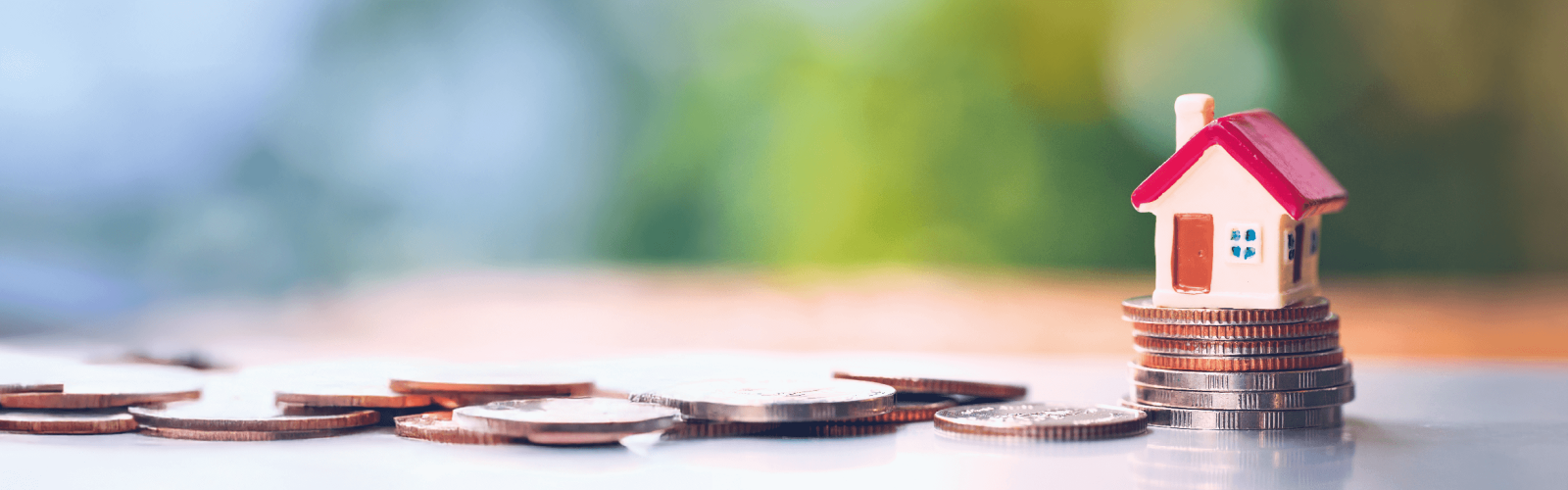 a small house toy on top of a stack of coins