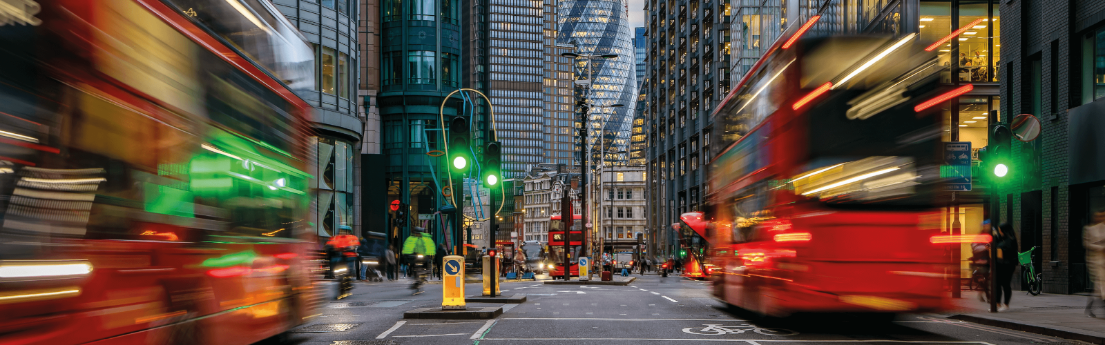 Image of road in central London with red buses and gherkin building in background