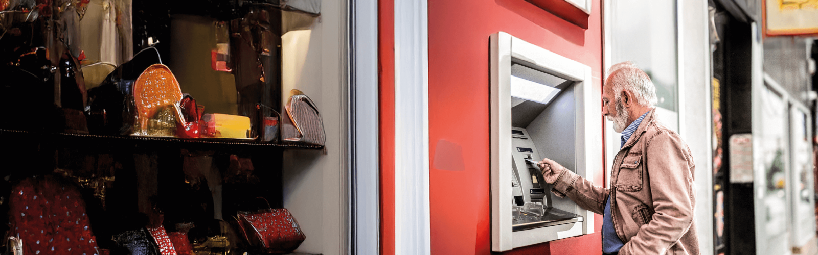 man at an ATM inserting card