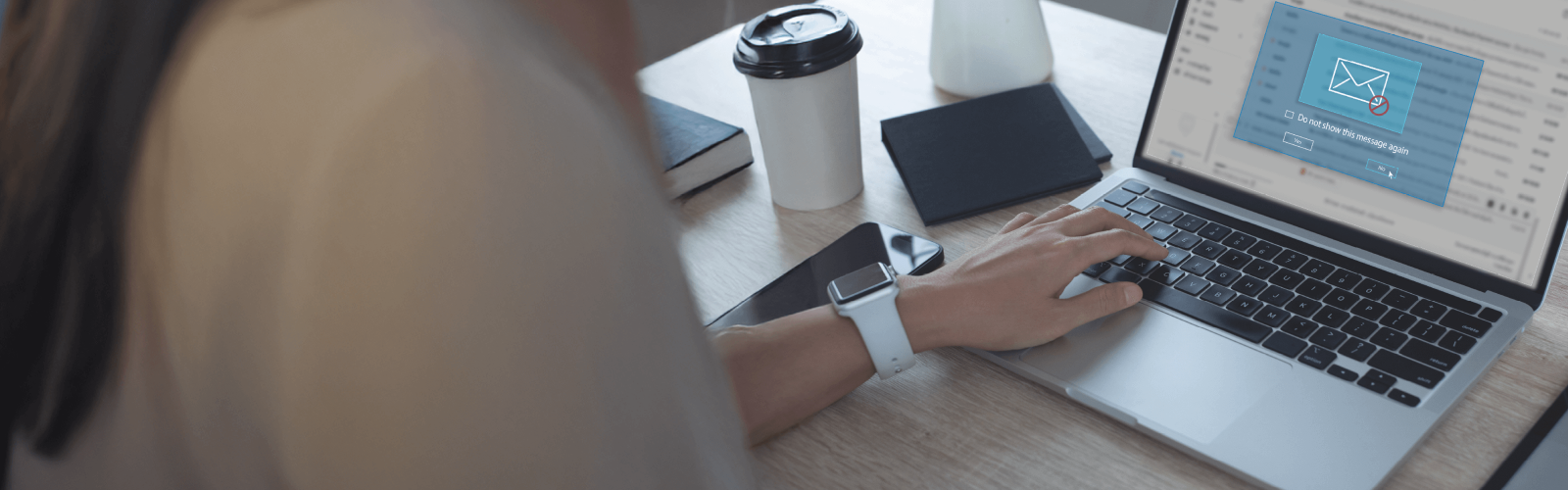 person typing on laptop with email interception notification