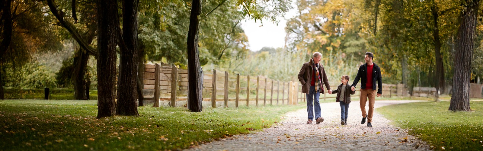 Grandfather, father and son walking through the countryside in Autumn