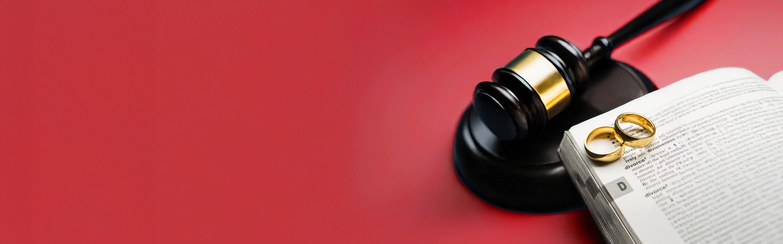 Two wedding rings placed on a book of law open on a page about divorce 