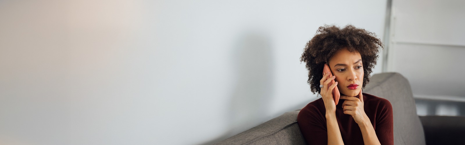 Woman sat on a sofa taking a phone call