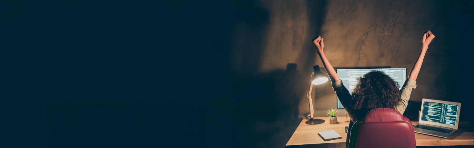 Woman sat at a desk working late on a computer