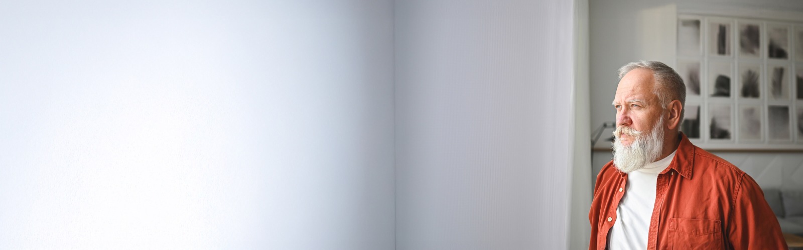 Man in red jacket looking out of window 