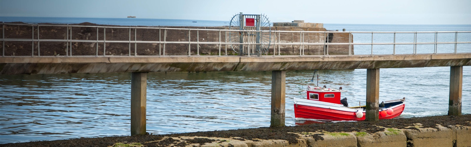 red boat along a pier 