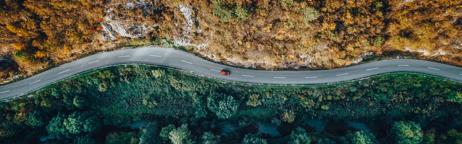 Red car driving on road