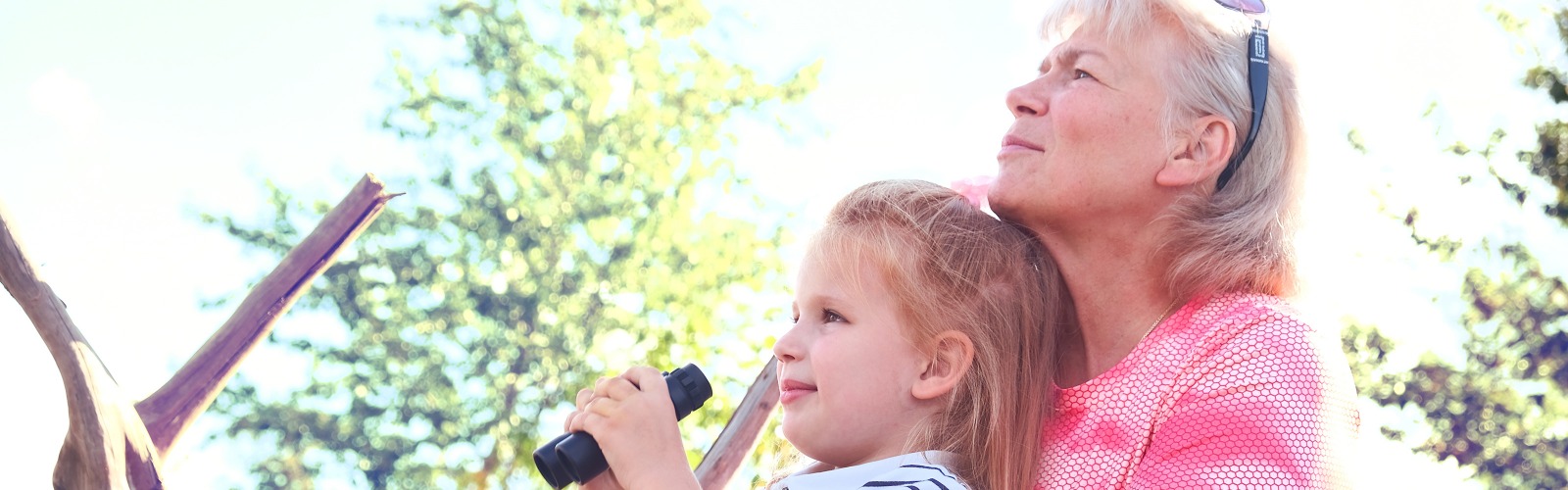 Grandma and grandchild using binoculars