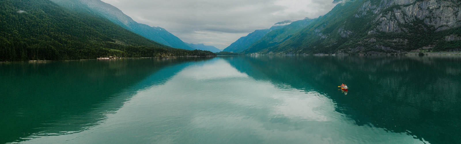 Image of rowboat in lake overlooking mountains