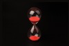 Red hourglass black background