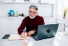 Man writing at desk in kitchen