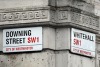 Downing street road sign on a grey building